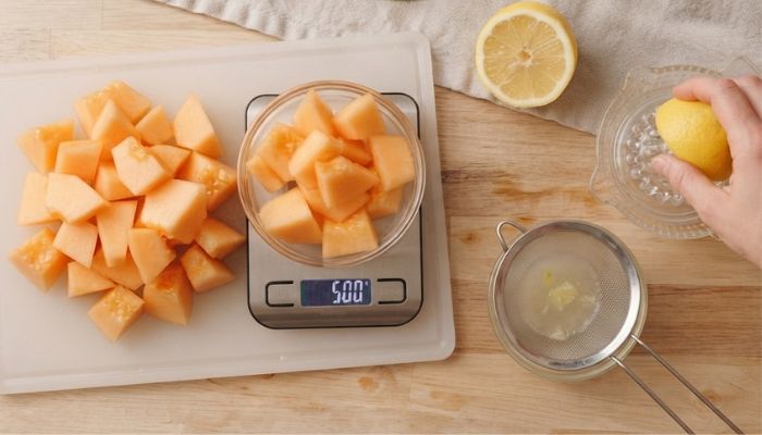 Polpa di melone cantalupo tagliata a pezzetti e succo di limone per i ghiaccioli