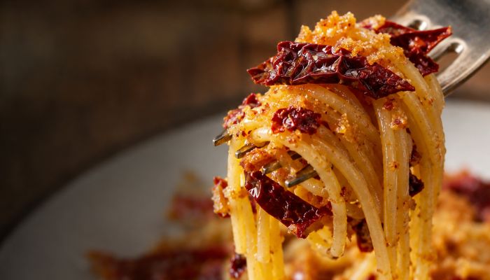 Spaghetti con peperone crusco e mollica attorcigliati ad una forchetta
