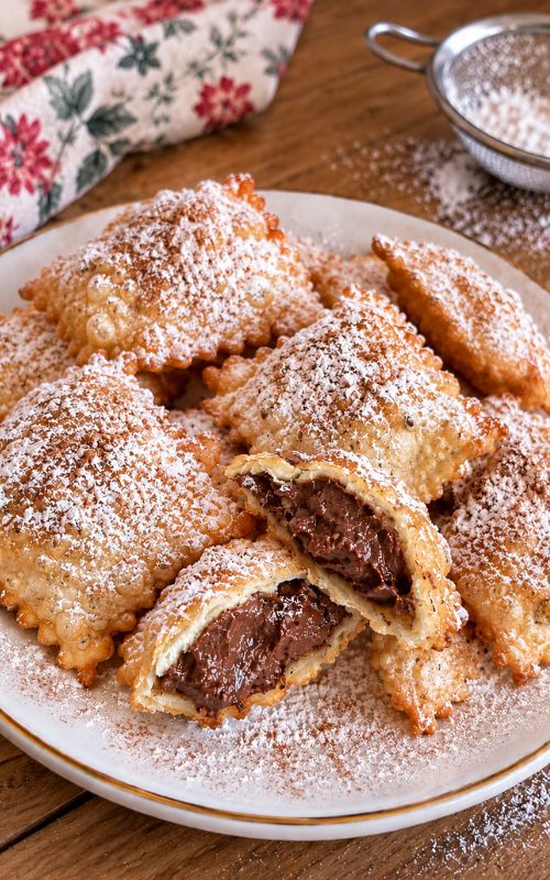 Calzoncelli lucani fritti con ripieno di castagne, ceci e cioccolato, caffè, spolverati con zucchero a velo e cannella