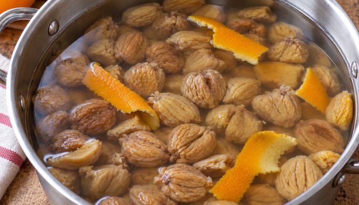 Castagne secche Munnaredda immerse nell’acqua con scorza d’arancia durante la cottura